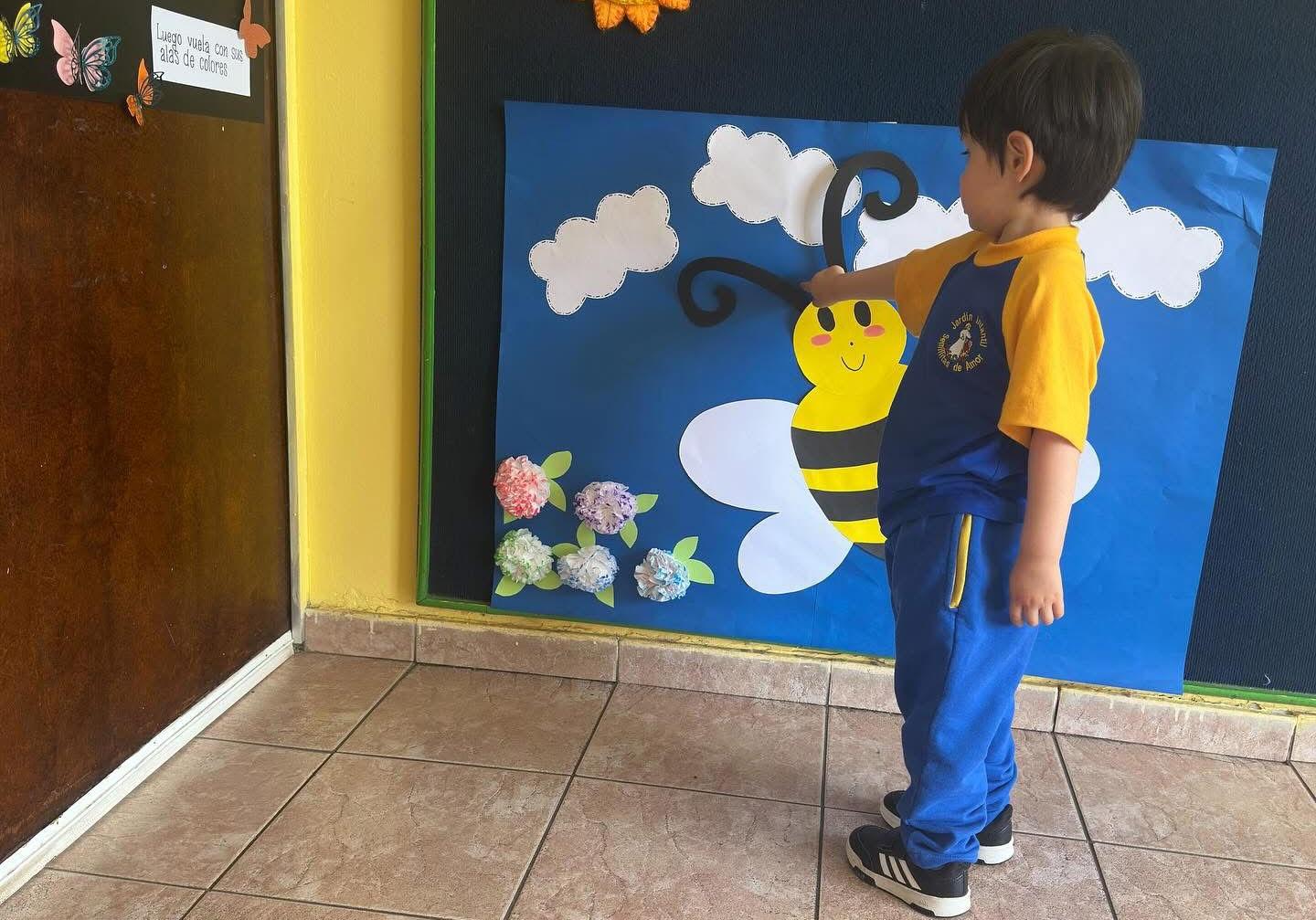 Niño observando mural educativo en Semillitas de Amor